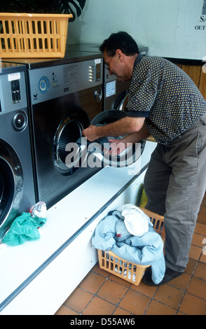 Man using launderette. Brixton, south London, UK. Stock Photo