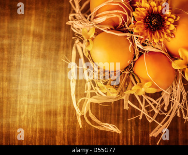 Beautiful Easter still life, chicken eggs in dry nest on wooden table, traditional Christian Eastertime symbol Stock Photo