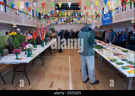 People view bright flowers & fresh veg produce displayed on tables in competition - Gardeners' Show, Burley-in-Wharfedale, Yorkshire, England, UK. Stock Photo