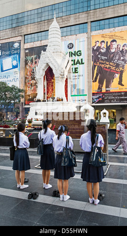 Schoolgirls at Ganesha-shrine in front of CentralWorld - shopping mall in Bangkok, Thailand, Asia Stock Photo