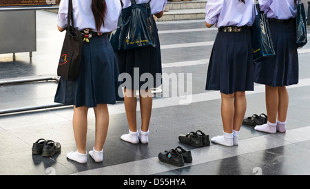 Schoolgirls at Ganesha-shrine in front of CentralWorld - shopping mall in Bangkok, Thailand, Asia Stock Photo