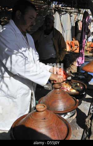 Tagine being cooked in traditional earthenware tagine pots  on market day at Jemaa D' Rehmat . South of Marrakech, Morocco Stock Photo