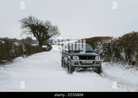 4x4 driving up a heavily snowed up road near Burton Dassett, Warwickshire, England, UK Stock Photo