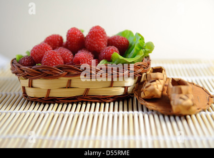 Fresh sweet raspberries in a wicker basket Stock Photo