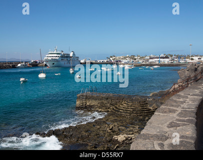 Armas ferry and moored boats in Playa Blanca Harbour, Lanzarote with Fuerteventura on the horizon Stock Photo