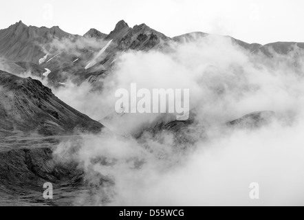 Black and white view of low clouds, mist and fog partially obscure the Alaska Range, Denali National Park, Alaska, USA Stock Photo