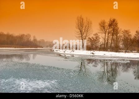 River with ice winds through a fogy forest Stock Photo