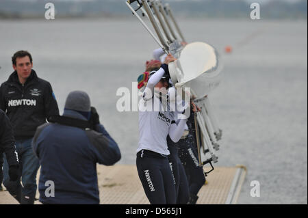 Eton Dorney, UK. 24th March 2013. The crew of the Oxford boat lifting it out of the water at the Dorney Lake jetty. Credit: Michael Preston / Alamy Live News Stock Photo
