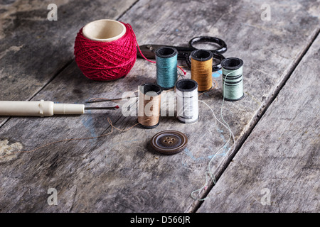 Many bobbin of thread with needle and button on table Stock Photo