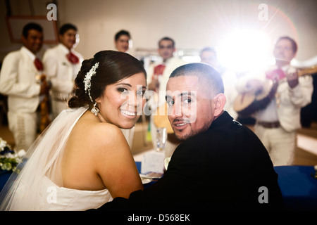 Hispanic bride and groom at wedding reception Stock Photo