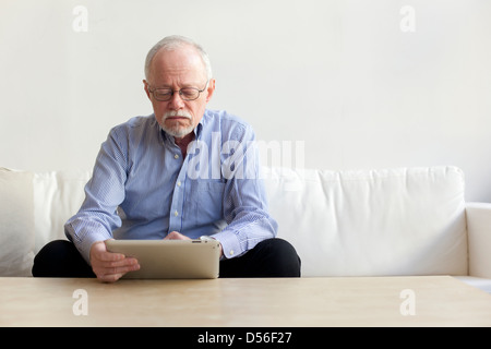 Caucasian man using tablet computer on sofa Stock Photo