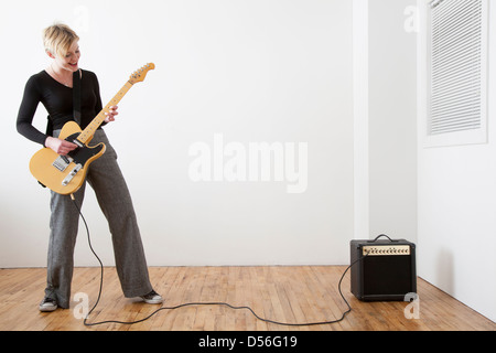 Caucasian woman playing electric guitar Stock Photo