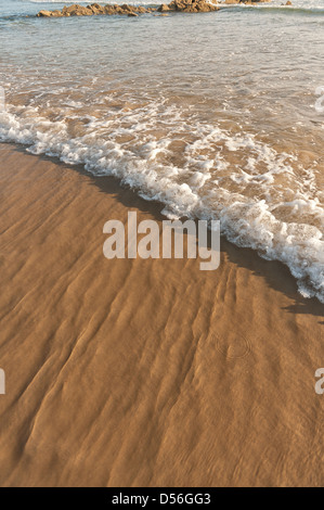 Low tide ripples reflections refraction stream wave patterns in shallow sea water as it draining water runs off sandy beach Stock Photo