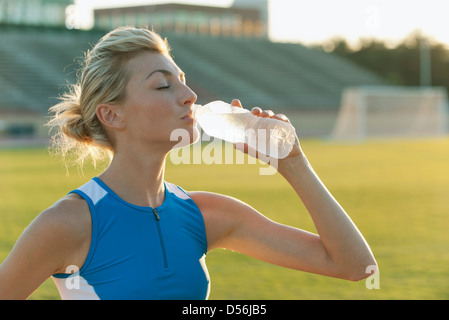 Female athlete drinking bottled water Stock Photo