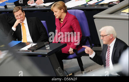 SPD parliamentary party leader Frank-Walter Steinmeier (front) speaks during the Bundestag budget debate in front of Chancellor Angela Merkel and Foreign Minister Guido Westerwelle (back) in Berlin, Germany, 17 March 2010. Steinmeier attacked the government harshly, accusing the CDU/FDP coalition of a complete lack of concept and inner disruption. Merkel prepared the citizens for a Stock Photo