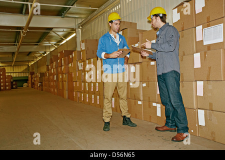 Caucasian workers talking in warehouse Stock Photo