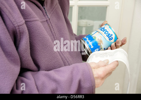 Elderly woman checking prices of shopping looking at till receipt bill Stock Photo