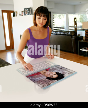 Mixed race woman using computer in table Stock Photo