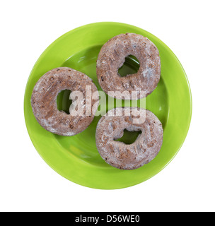 Top view of three fresh chocolate donuts on a green plate. Stock Photo