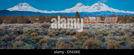 Ranch house with the Three Sisters peaks in Oregon behind it Stock Photo