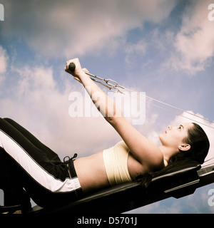 Woman using exercise machine outdoors Stock Photo