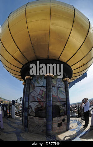 Ein Besucher fotografiert am Freitag (23.04.2010) die goldene Kugel des Hundertwasserturms in Abensberg (Niederbayern). Er ist 35 Meter hoch und wirkt in Niederbayern wie ein Exot aus Aladins Märchenwelt - seit Freitag ist das letzte Architekturprojekt von Friedensreich Hundertwasser auch offiziell geöffnet. Der Abensberger Hundertwasserturm soll in Zukunft jedes Jahr mindestens 50 Stock Photo