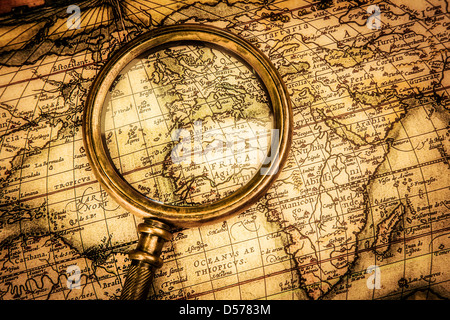 Vintage Compass and magnifying glass lies on an ancient world map ...