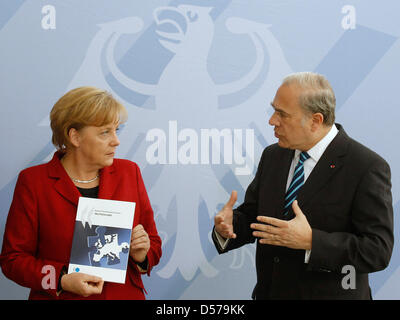 Angel Gurria (R), Secretary General of the Organisation for Economic Co-Operation and Development (OECD), hands over the annual OECD report to German Chancellor Angela Merkel in Berlin, Germany, 28 April 2010. The title reads 'Better Law-making in Europe'. Photo: Tobias Schwarz Stock Photo