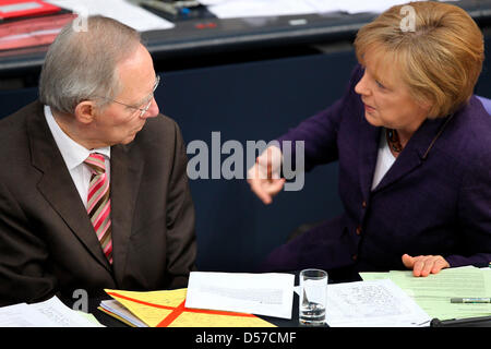 German Chancellor Angela Merkel (R) and Federal Minister of Finances Wolfgang Schaeuble discuss during a debate in the German Bundestag in Berlin, Germany, 07 May 2010. A vast majority of the German Bundestag voted in favour of the Greek credit line. While Germany's coalition government can count on The Greens, Germany's Social Democratic Party is likely to abstain from voting. Pho Stock Photo