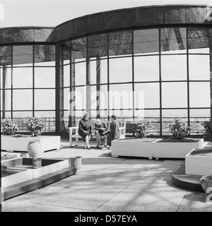 1950s, Paris, France, ladies sitting on a bench outside in the open-air on the first level of the famous french monument, the Eiffel tower, a wrought-iron lattice tower on the Champs de Mars. Large windows can be seen in the picture allowing a view over the city. Stock Photo