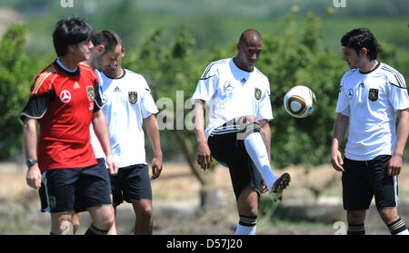 Germany's Jerome Boateng (2-R) plays a ball next to team colleague Serdar Tasci (R) and coach Joachim Loew (L) during a training session in Sicilian Sciacca, Italy, 18 May 2010. On the Italian island Sicily, the German national soccer squad prepares themselves for the 2010 FIFA World Cup in South Africa. Photo: MARCUS BRANDT Stock Photo