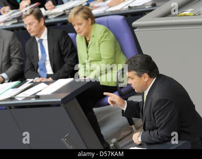 German Chancellor Angela Merkel (C) and German Foreign Minister Guido Westerwelle (L) listen to a speech of Sigmar Gabriel, chairman of Germany's Social Democratic Party, during a meeting of the German Bundestag in the plenary hall of the German Bundestag in Berlin, Germany, 21 May 2010. Bundestag and Bundesrat will decide on the German share in the 750-billion-Euro rescue package  Stock Photo