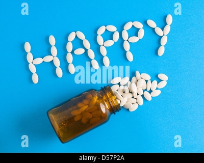 Word 'happy' written whith pills on blue background. The photo is to convey a concept of excess medicines in modern life. Stock Photo