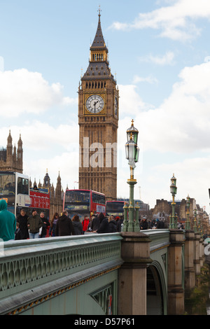 People and buses crossing the Westminster Bridge in view of Big Ben (Elizabeth Clock Tower) Stock Photo