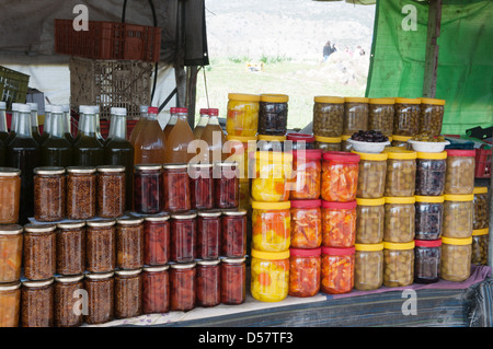 canned at home fruit vegetables and berries on the shelves of rural market Stock Photo