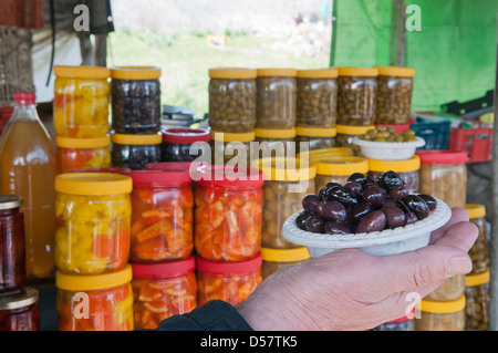 canned at home fruit vegetables and berries on the shelves of rural market Stock Photo