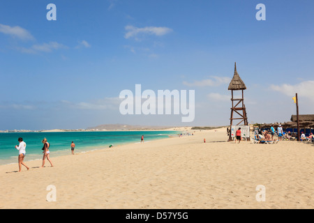 View along sandy seashore to Riu Karamboa beach resort hotel with holiday makers on Praia de Salinas, Boa Vista, Cape Verde Stock Photo