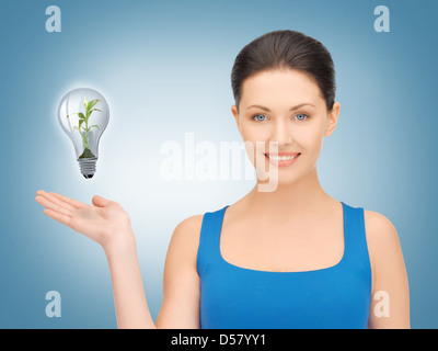 woman showing green light bulb Stock Photo