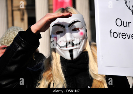 A protester wearing an anonymous mask at a rally in Trafalgar Square, London Stock Photo