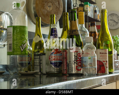 Empty bollles and cans waiting for disposal on a kitchen work surface Stock Photo