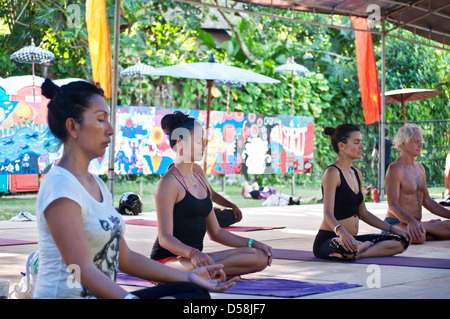 Bali, Indonesia-march 20, 2013: Rows of male and female adults, lying on colourful mats in a yoga class at Bali Spirit Festival. Stock Photo