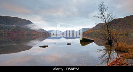 Dawn at Ullswater in the Lake district, Cumbria, England on a Autumn morning with the trees and mountains reflected in the water Stock Photo