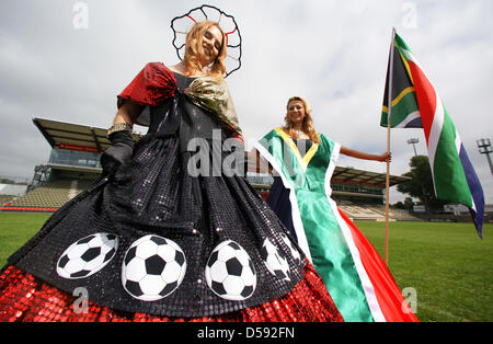 Miray Barasik (L) and Sandra Schmidt (R) present 'Ball Dresses' creations by Manuela Offenborn (C) within the scope of FIFA 2010 World Cup in Lohmuehle, Germany, 04 June 2010. The soccer-enthusiastic designer made the hooped skirts with the national colours of host South Africa, the German squad and all European qualified countries. Photo: JENS BUETTNER Stock Photo
