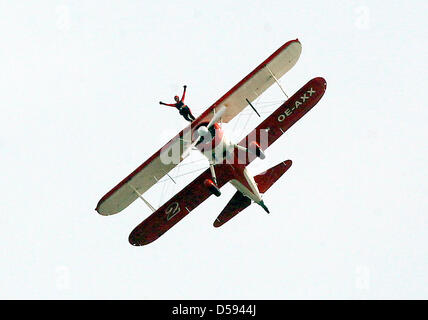 'Lady King Walker' Peggy Krainz performs acrobatics on the deck of a Boeing Stearman PT 17 during the International Aerospace Show ILA 2010 in Schoenefeld Germany, 11 June 2010. A total of 1,153 exhibitors from 47 nations present some 300 airplanes, products and product ideas from 08 June to 13 June 2010. Photo: WOLFGANG KUMM Stock Photo