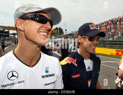 Germany's Formula One driver Sebastian Vettel of Team Red Bull and Germany's Formula One driver Michael Schumacher (L) of Mercedes GP walk together to the driver's parade prior to the Formula One Grand Prix of Canada  in Montreal, Canada, 13 June 2010. Photo: JENS BUETTNER Stock Photo