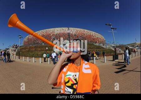 A Dutch fan blows a vuvuzela in front of the stadion prior to the 2010 FIFA World Cup group E match between the Netherlands and Denmark at Soccer City stadium in Johannesburg, South Africa, 14 June 2010. Photo: Achim Scheidemann - Please refer to http://dpaq.de/FIFA-WM2010-TC Stock Photo
