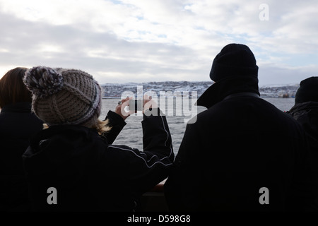 passengers on cruise ship taking photos on arrival into kirkenes finnmark norway europe Stock Photo