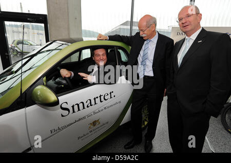 Stefan Mappus (L-R), Prime Minister of Baden-Wuerttemberg, sits in a 'smart electric drive' which stands next to Dieter Zetsche, CEO of Daimler AG and Hans-Peter Villis, CEO of EnBW, in Stuttgart, Germany, 18 June 2010. Car manufacturer Daimler, power supplier EnBW and Baden-Wuerttemberg want to build about 700 loading stations until the end of 2011 and test 200 vehicles with elect Stock Photo