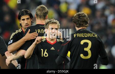 Germany's captain Philipp Lahm (C) celebrates with team mates Sami Khedira (L-R), Marcell Jansen and Arne Friedrich after the 2010 FIFA World Cup group D match between Ghana and Germany at Soccer City, Johannesburg, South Africa 23 June 2010. Photo: Marcus Brandt dpa - Please refer to http://dpaq.de/FIFA-WM2010-TC  +++(c) dpa - Bildfunk+++ Stock Photo