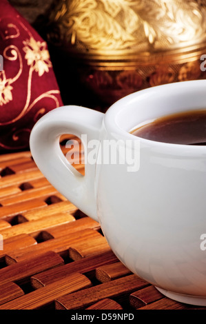 White cup of coffee on a wooden stand Stock Photo